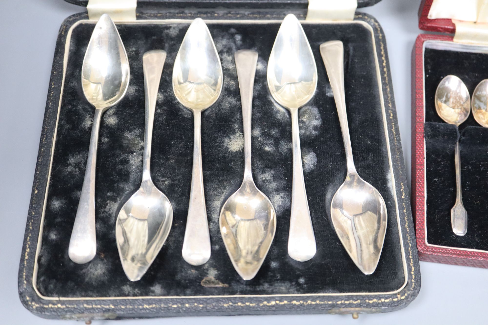 A set of six silver grapefruit spoons and a set of six silver coffee spoons, both cased, 5.5oz.